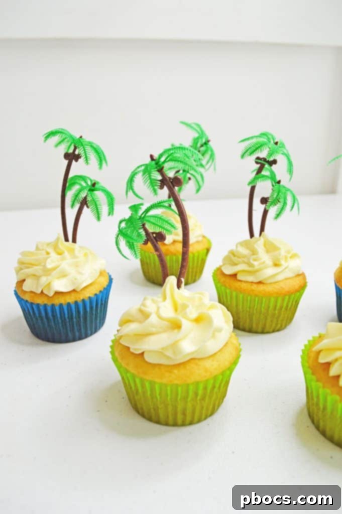 Chicka Boom Alphabet Treats 11 A cupcake decorated with white frosting, a green palm tree topper, and several colorful candy letters.