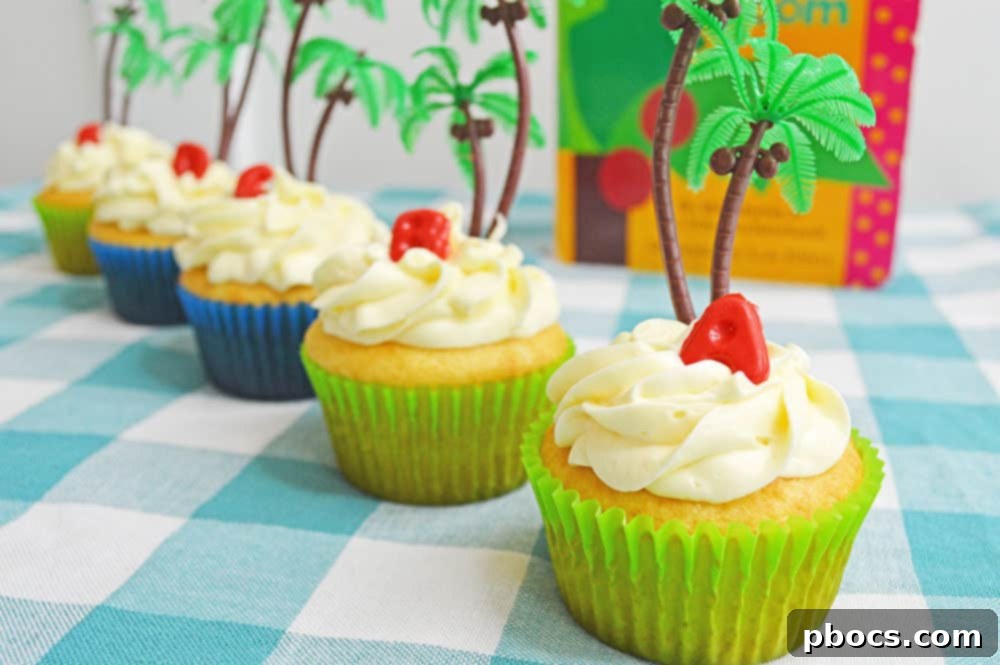 Chicka Boom Alphabet Treats 3 A close-up of several Chicka Chicka Boom Boom cupcakes arranged on a white serving tray, showcasing their colorful candy letters and tropical palm tree decorations.