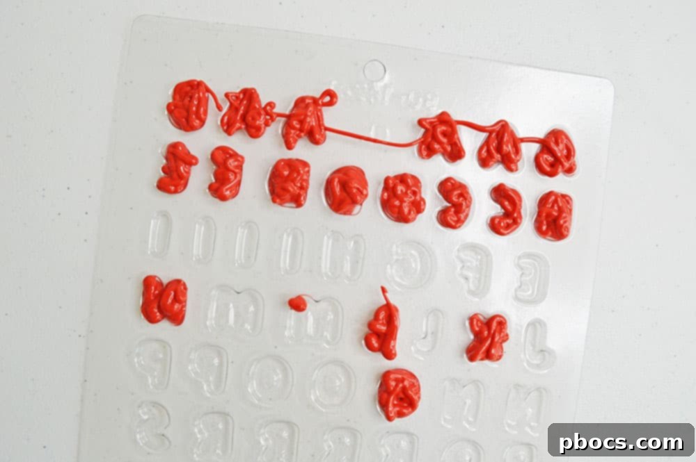 Chicka Boom Alphabet Treats 8 A silicone mold filled with various colored candy letters, ready to be chilled.