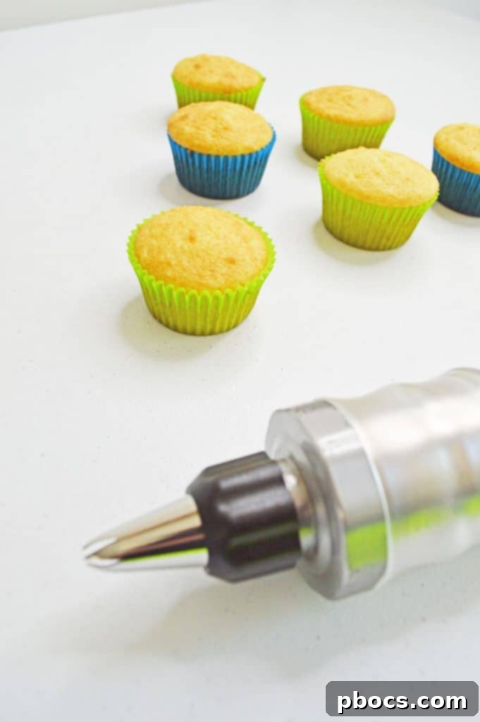 Chicka Boom Alphabet Treats 9 Butter, cream cheese, and vanilla extract being beaten together in a large mixing bowl for the frosting.
