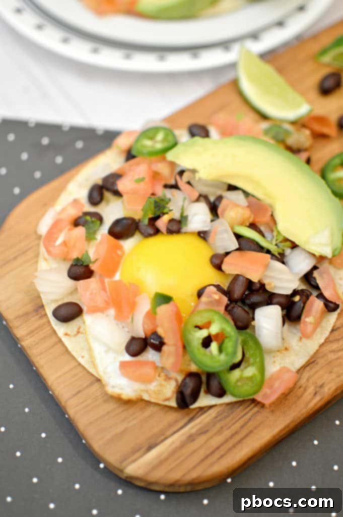 Savory Black Bean Morning Tacos 2 Hand assembling a black bean breakfast taco with egg, avocado, and pico de gallo