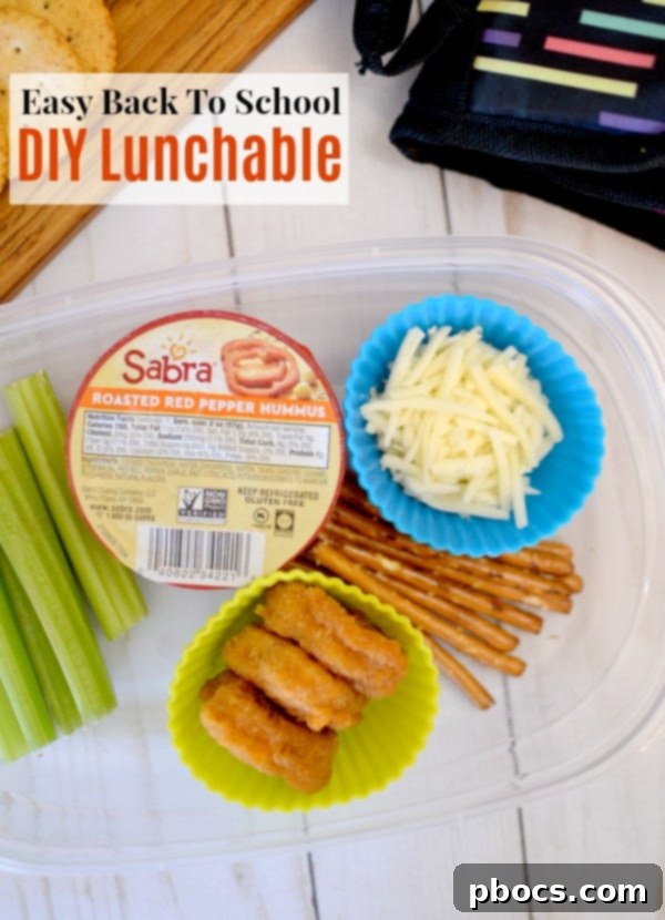 Two children sitting at a table with their DIY lunchables, happily eating.
