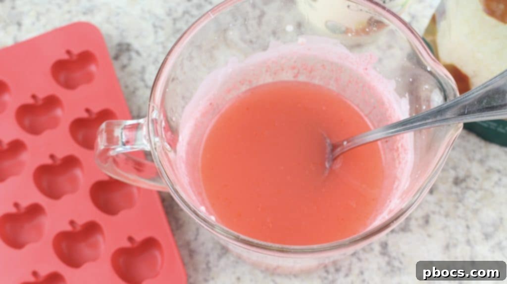 Craft Your Own Apple Lotion Bars 6 Thoroughly mixing red soap colorant into the apple-scented lotion bar base to achieve a uniform red color.