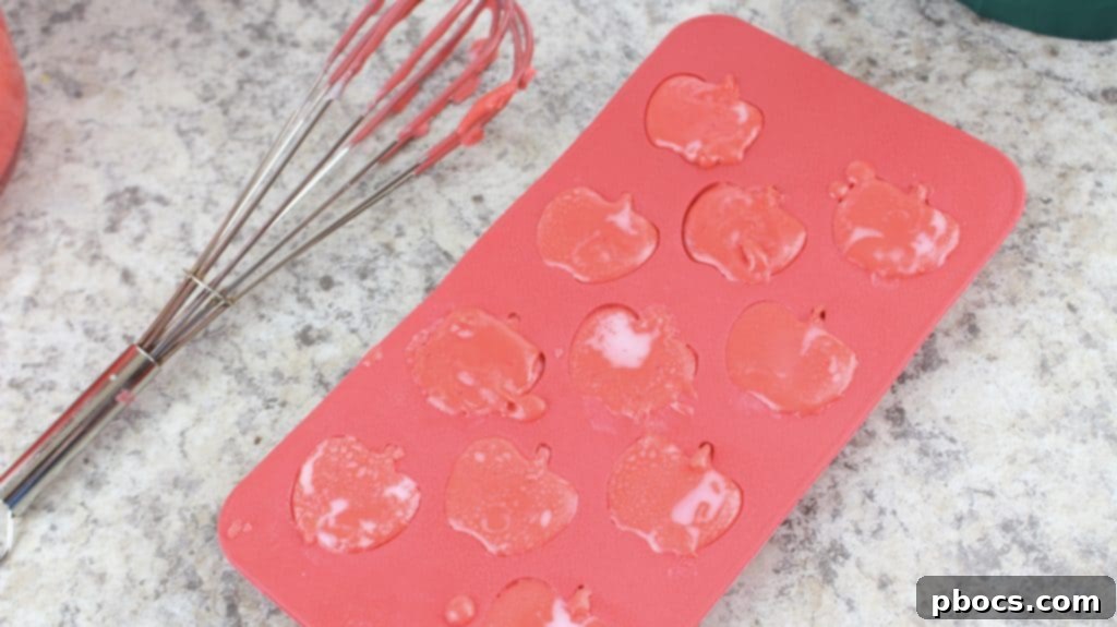 Craft Your Own Apple Lotion Bars 7 Carefully pouring the vibrant red apple-scented lotion mixture into individual silicone molds.