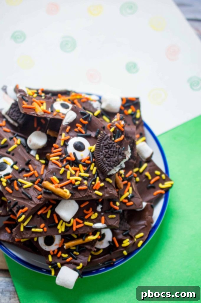 Close-up of finished Halloween candy bark with candy eyes, pretzels, Oreos, and sprinkles
