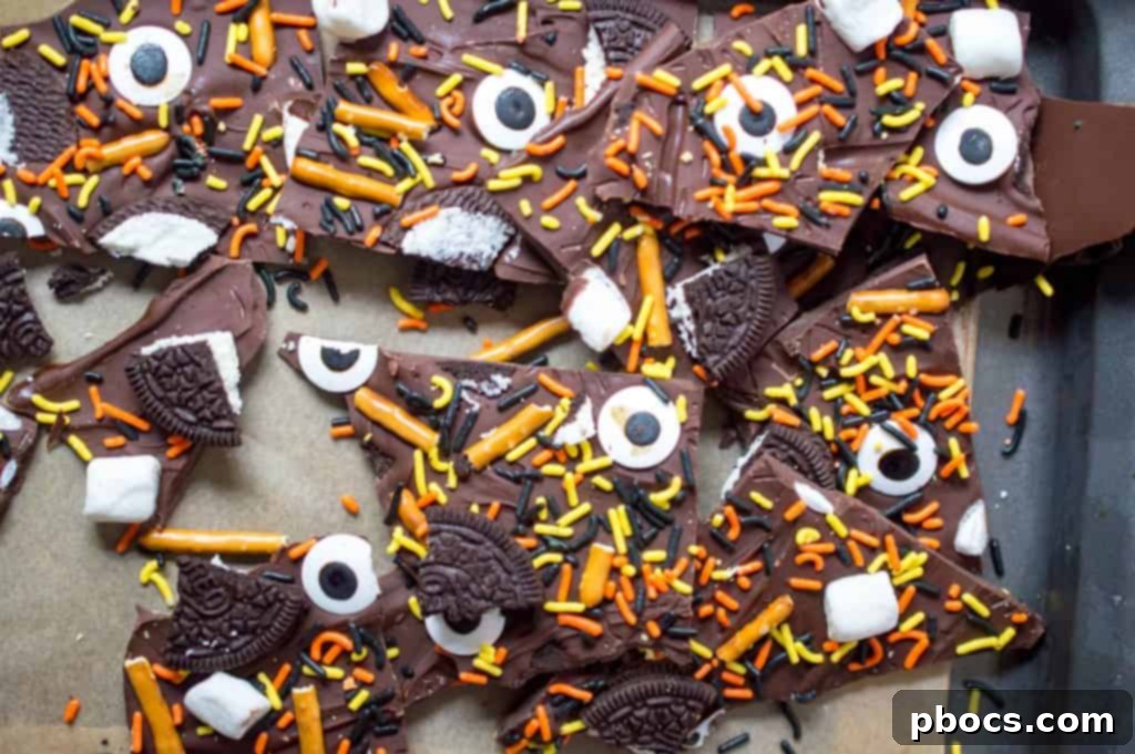 Hand breaking a sheet of Halloween chocolate bark into edible pieces