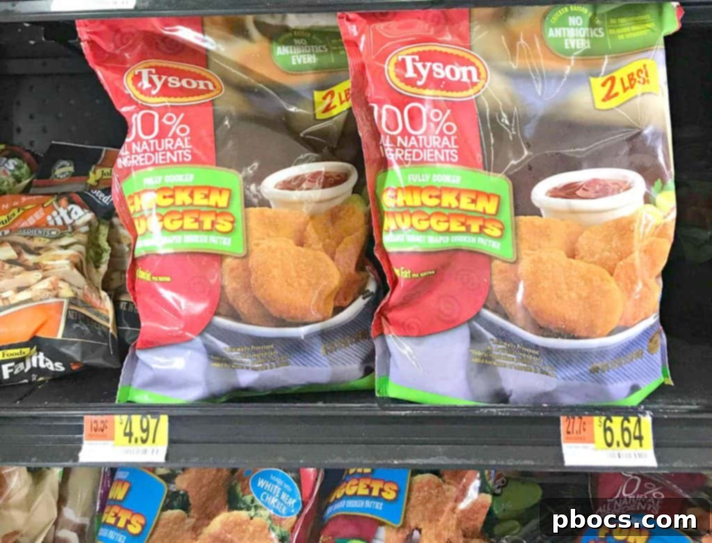 Two hands holding Halloween chicken nugget spider bites, showcasing their appeal.