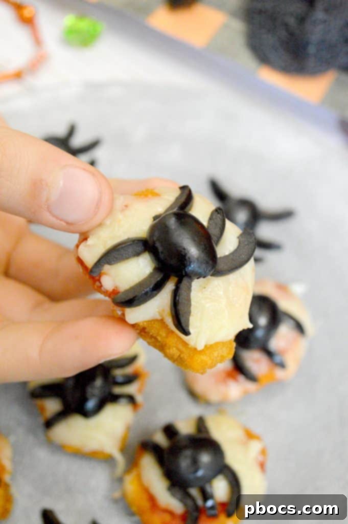 A child eagerly reaching for one of the festive Halloween chicken nugget spider bites.