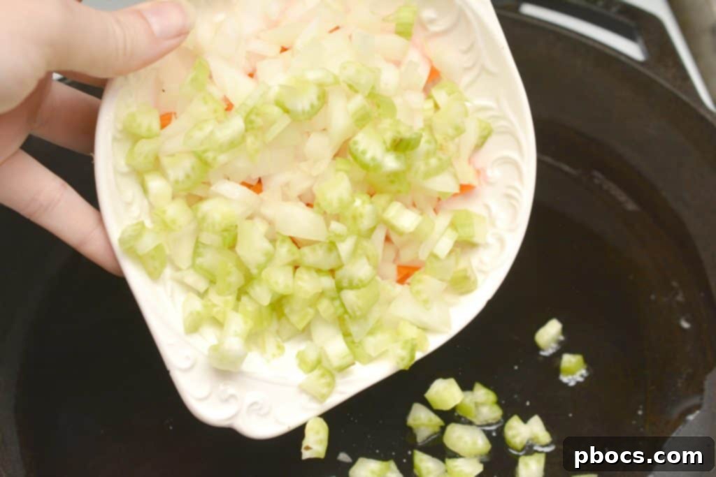 Sautéing diced onions, celery, and carrots in olive oil