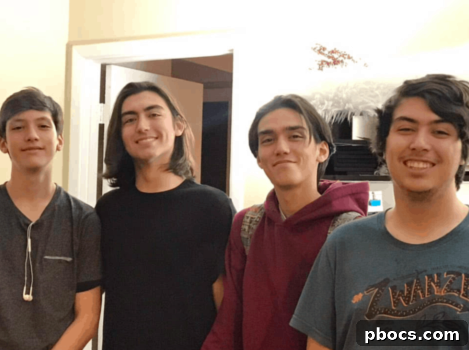 A young girl smiling and playing an acoustic guitar, focusing intently on the strings.