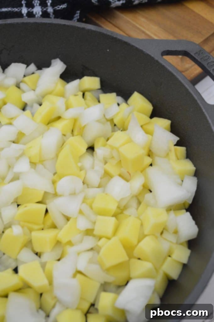 Potatoes and onions cooking in a skillet until soft and golden