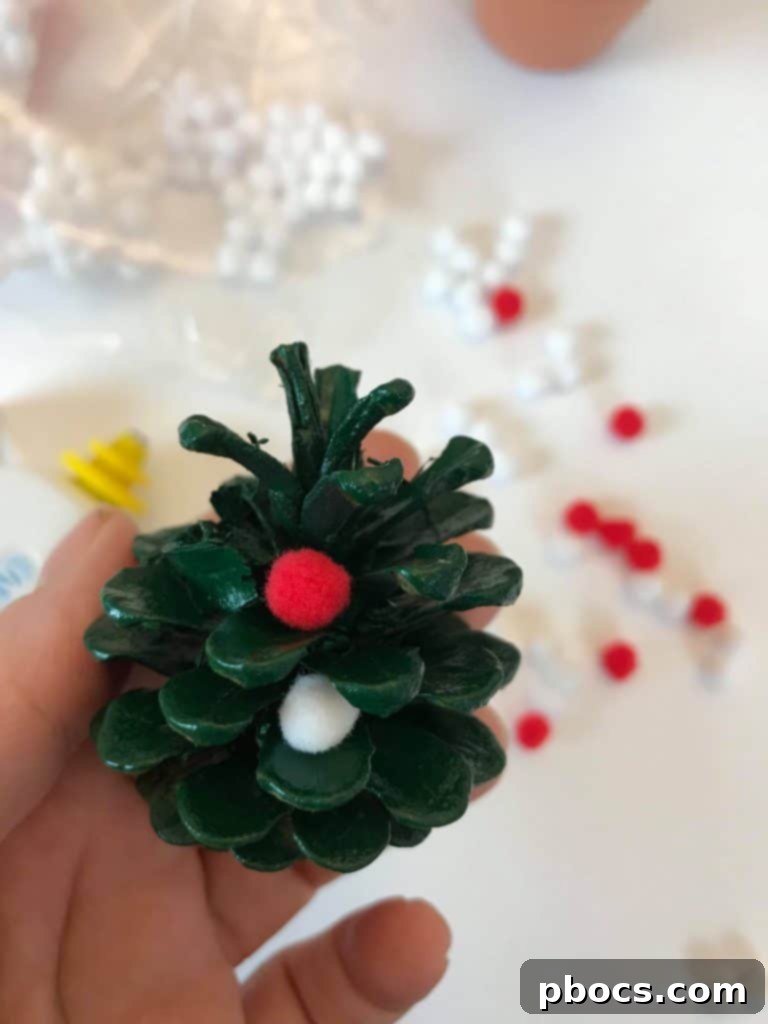 Gluing Pom Poms on Pinecone Christmas Trees