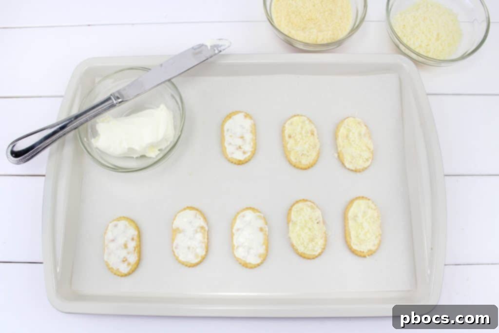 Frosty's Farewell Cheeseball 6 Spreading cream cheese on crackers and sprinkling with parmesan and mozzarella cheese.