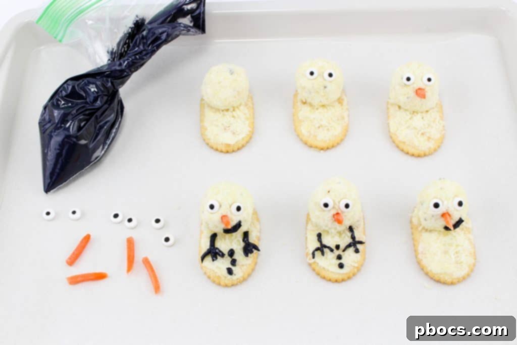 Frosty's Farewell Cheeseball 8 Adding edible eyes and a shredded carrot nose to the snowman cheeseball heads.