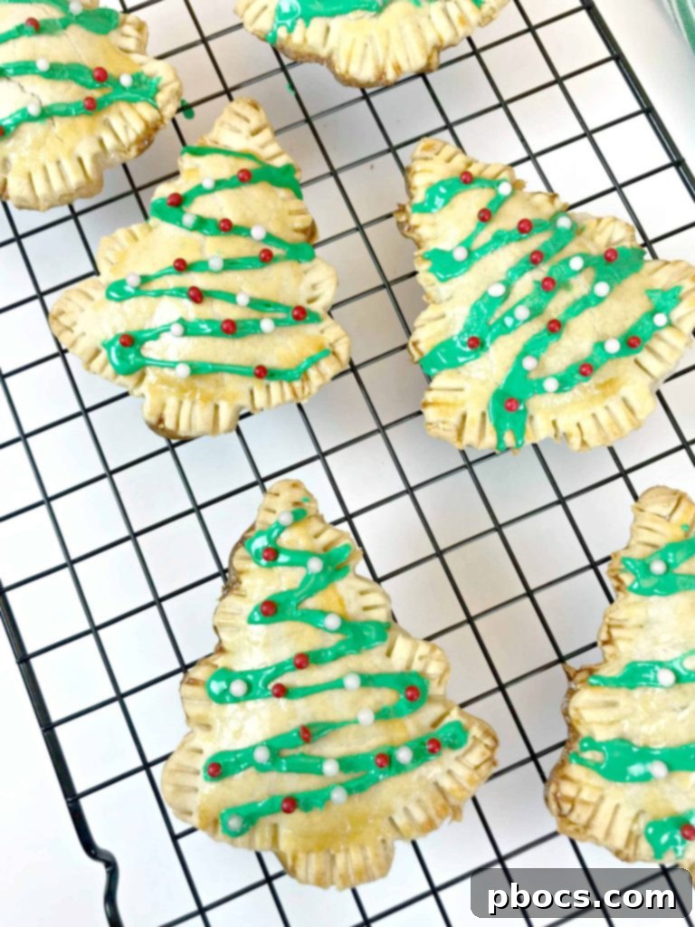 No-Fuss Festive Tree Treats 13 Decorating baked Christmas tree pastries with white icing and red and white sprinkles.