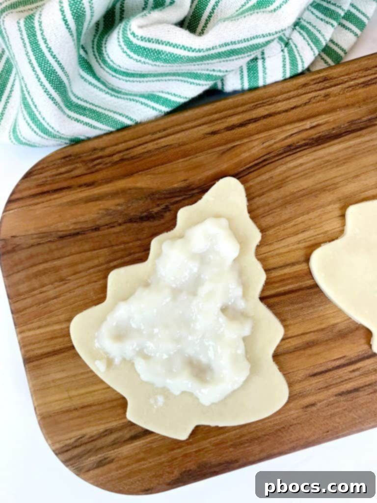 No-Fuss Festive Tree Treats 9 Placing pudding filling onto pie crust Christmas tree cut-outs.