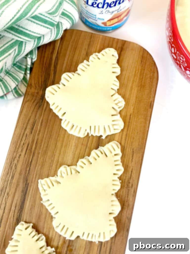 No-Fuss Festive Tree Treats 10 Sealing the edges of the Christmas tree pastries with a fork.