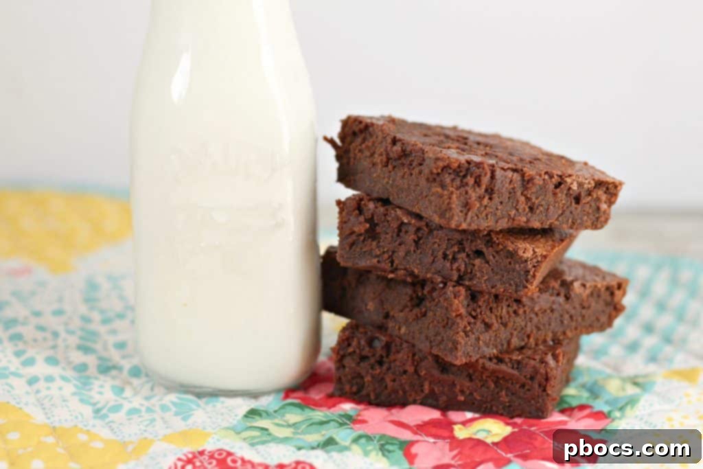 Fudgy Greek Yogurt Brownies 4 A beautifully presented serving of Greek yogurt brownies, cut into neat squares on a wooden surface.