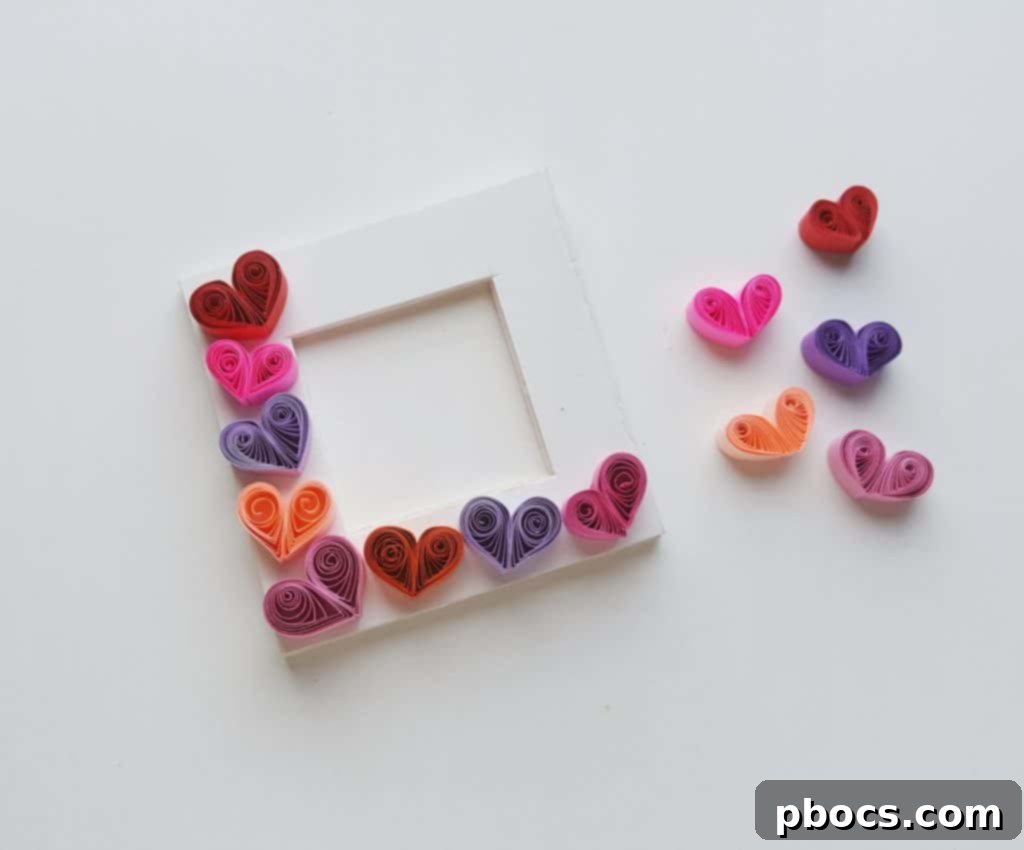 Gluing first quilled hearts onto the photo frame