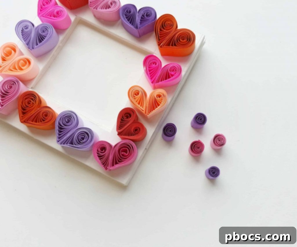 Continuing to glue quilled hearts to fill the frame