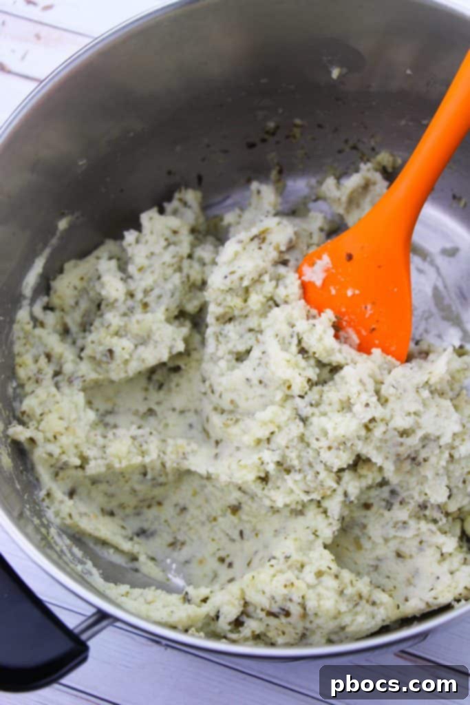 Creamy Keto Cauliflower Mash 8 Adding milk and butter to mashed cauliflower for a creamy texture.