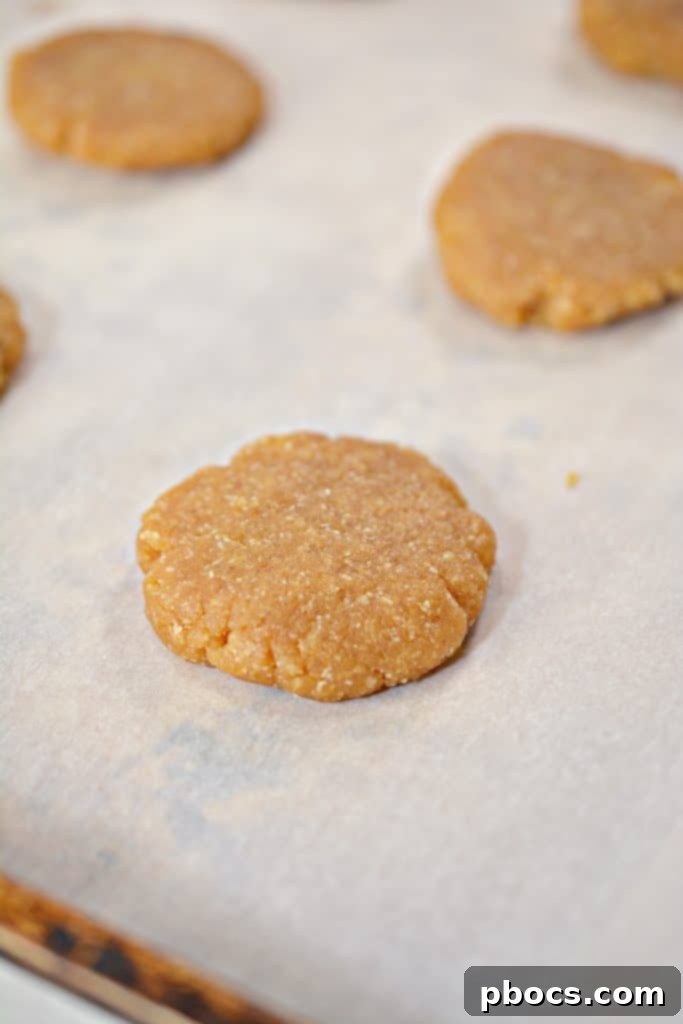 Crisscross pattern being made on keto peanut butter cookies with a fork