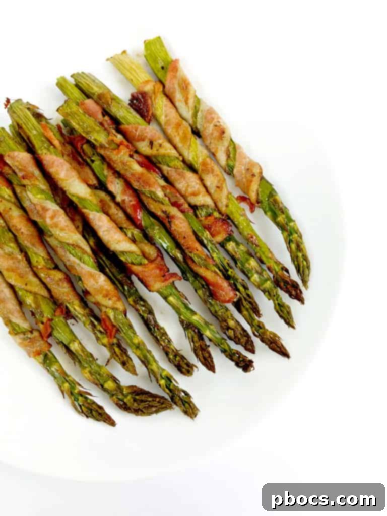 A tray of uncooked Keto Bacon Wrapped Asparagus ready for the oven