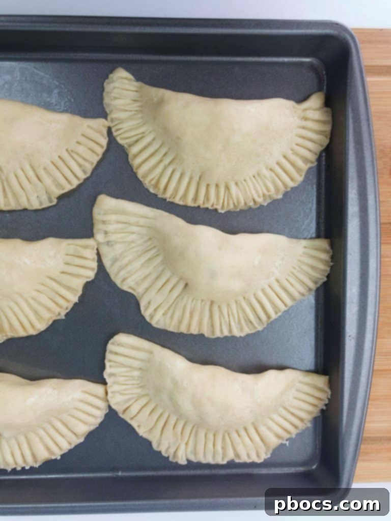 Sealing Empanadas with a fork for a secure and decorative edge