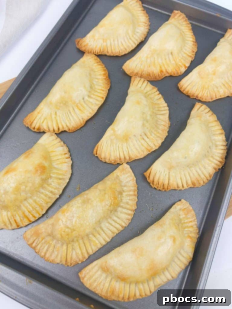 Brushing Empanadas with egg wash before baking