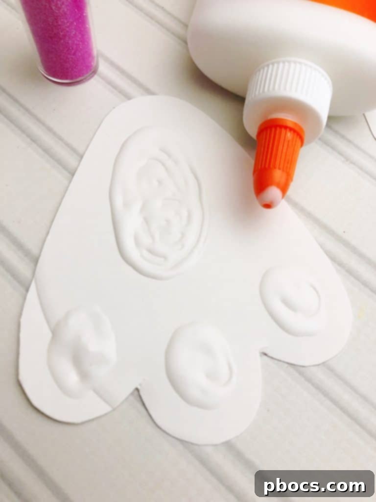 Adorable Paper Plate Bunny Craft 6 Applying Glue for Glitter on Bunny Feet