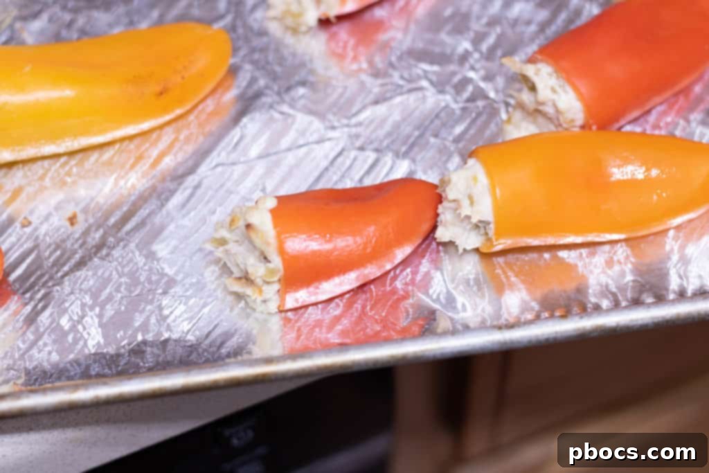 Shredded rotisserie chicken being folded into the cream cheese and chile mixture
