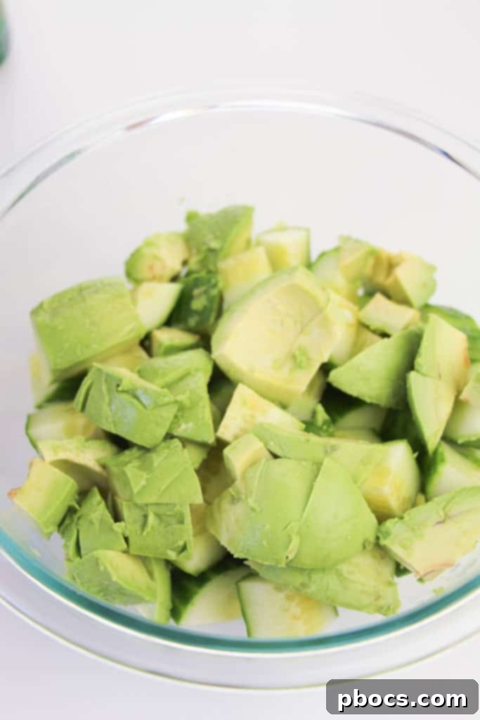 Mixing Low Carb Avocado Cucumber Salad ingredients in a bowl