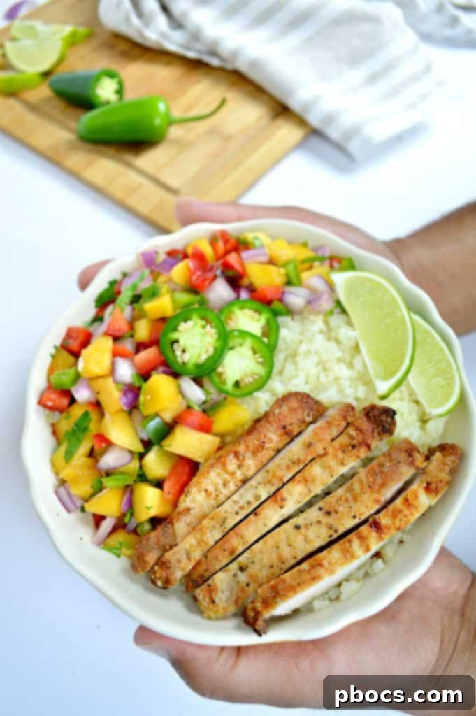 Finished plate of Grilled Pork Chops & Peach Salsa with avocado and lime