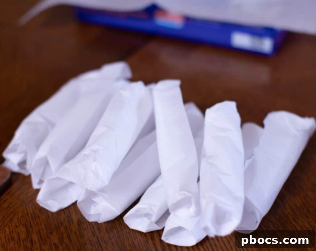 Dynamite Chicken Jalapeño Poppers 6 Parchment Paper Rolled into Tubes on a Baking Sheet