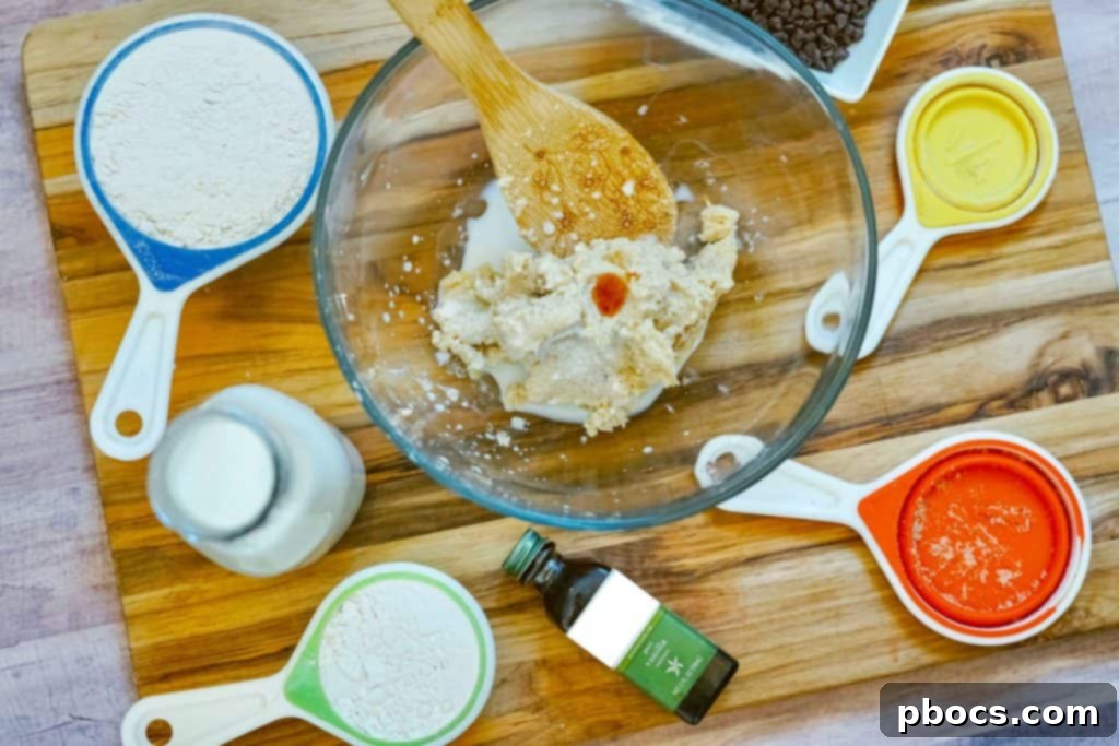 Adding vanilla extract to the cookie dough mixture.