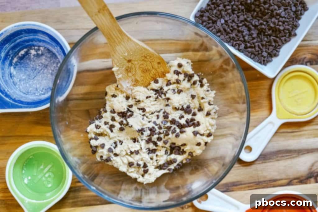 Folding chocolate chips into the edible cookie dough.