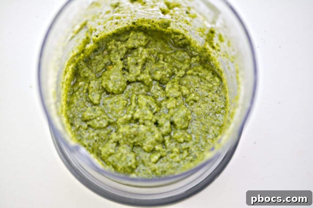 Vibrant Keto Pesto Salmon Bowl 11 Keto Pesto Salmon Bowl - Pouring olive oil into the food processor for pesto