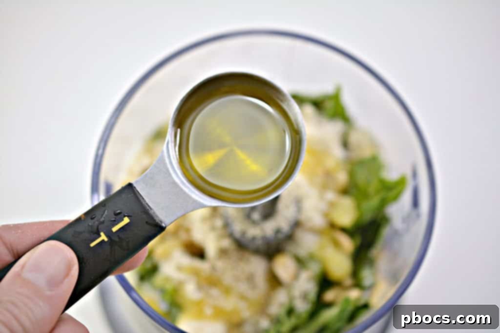 Vibrant Keto Pesto Salmon Bowl 10 Keto Pesto Salmon Bowl - Adding fresh basil leaves to the food processor