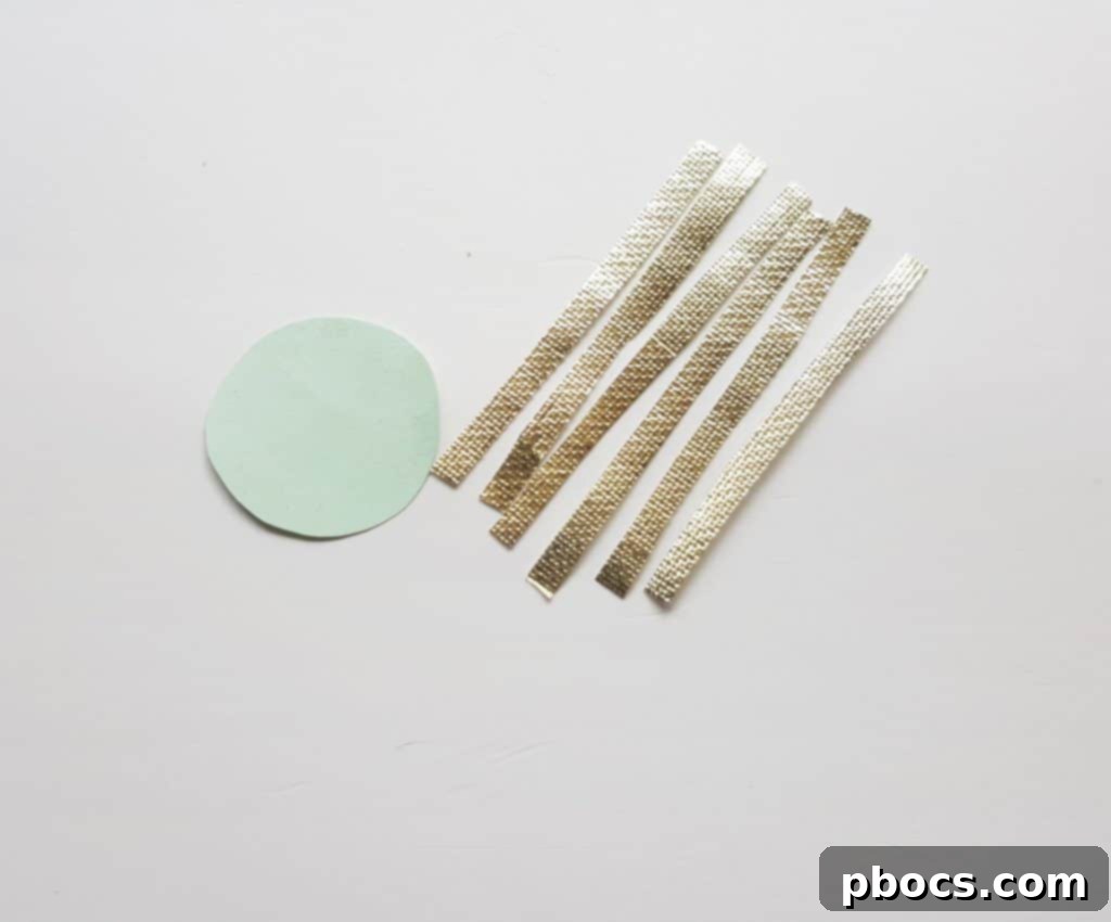Cutting a round base and thin strips from golden craft paper