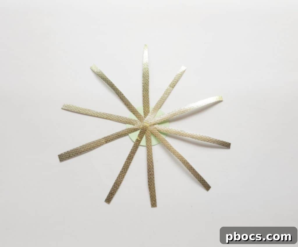 Attaching golden strips to the round paper base