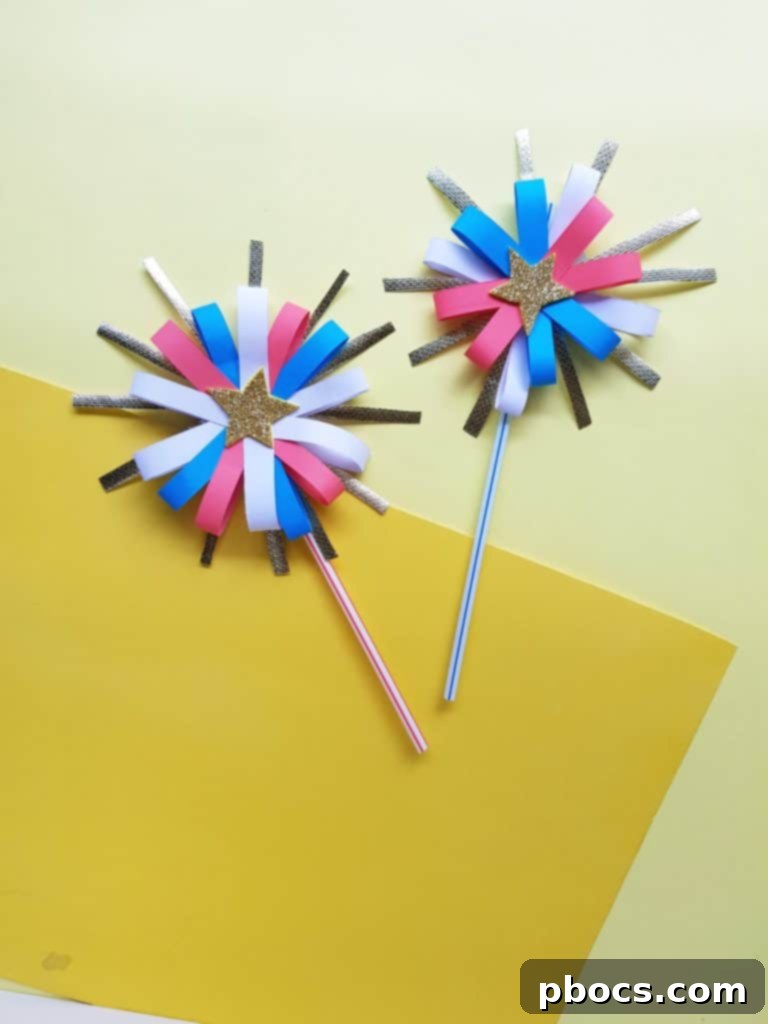 A collection of finished paper firework wands in red, white, and blue