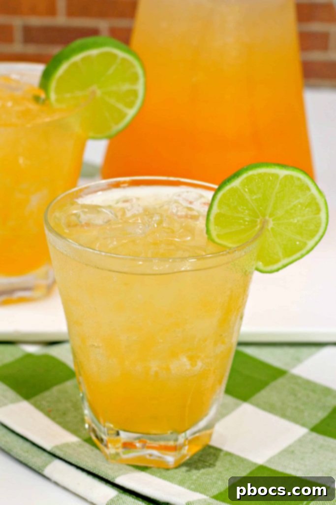 Cantaloupe Tequila Spritzer in a glass, garnished with mint