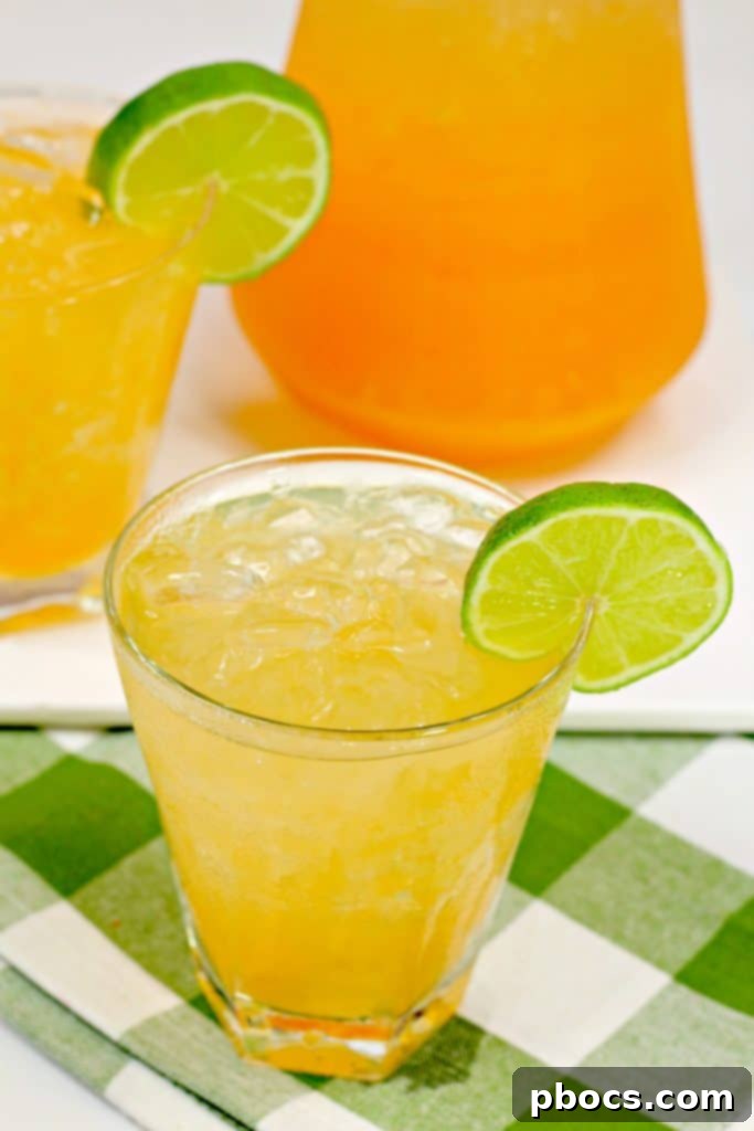 Tequila Cantaloupe Spritzer cocktail glass on a wooden surface with melon and mint