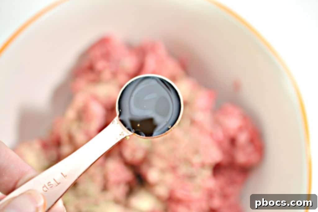 Keto Bacon Cheeseburger Pops 9 Hands mixing ground beef with spices for bacon wrapped cheeseburger lollipops