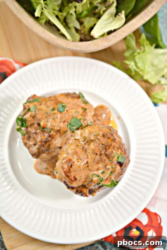 Close-up view of cooked Keto Feta Burgers with tomato cream sauce, showing texture and garnish