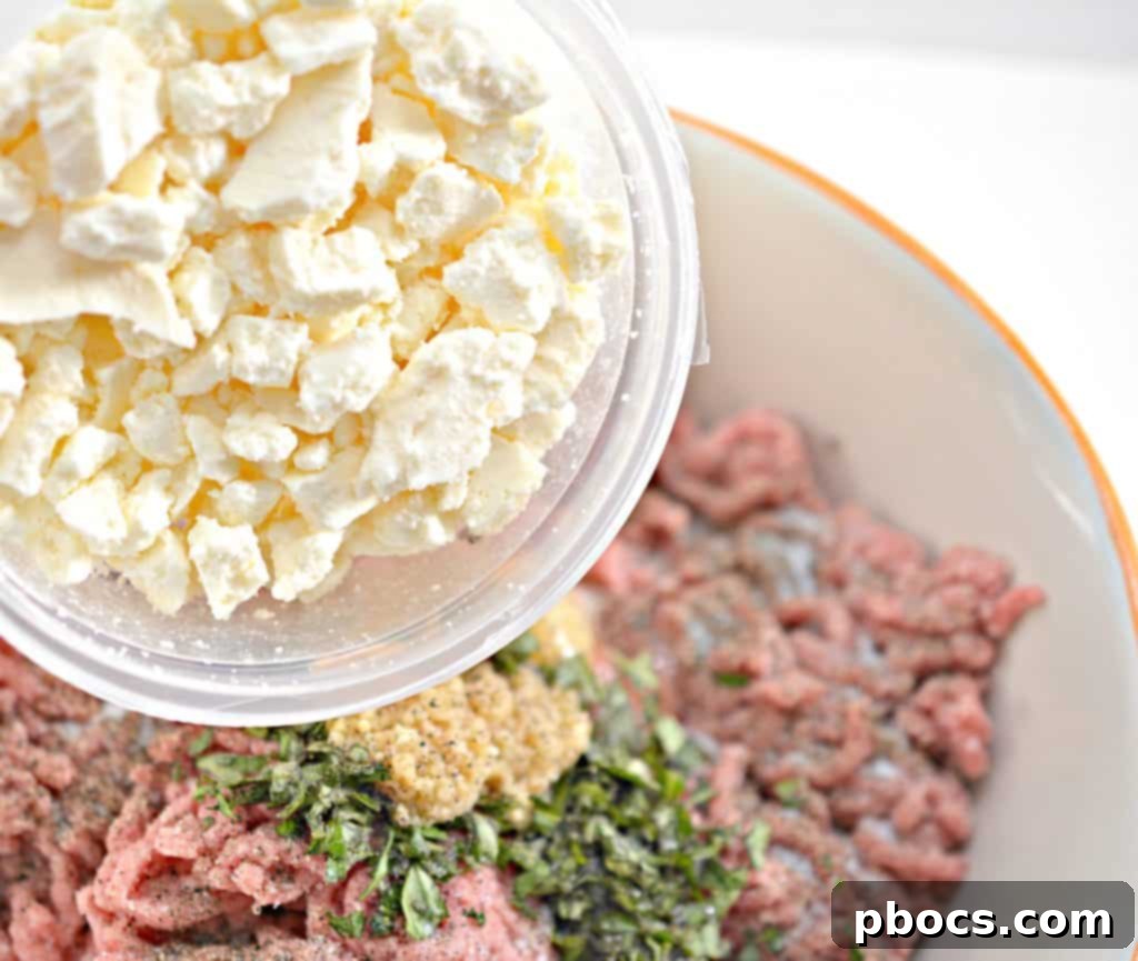 Mixing ground beef, feta cheese, and herbs in a bowl for Keto Feta Burgers