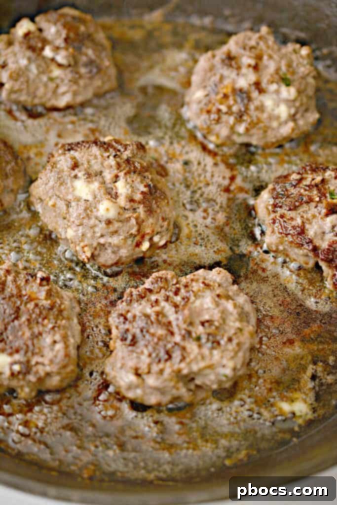 Cooked Keto Feta Burger patties neatly arranged on a tray, ready for sauce