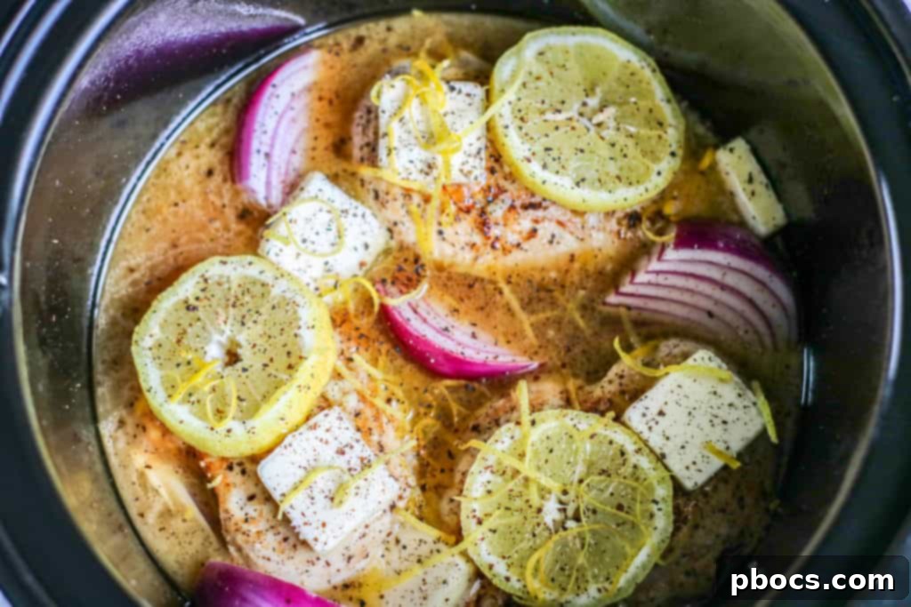 Velvety Lemon Keto Chicken 12 Slow cooker interior with cooked chicken, onions, and broth