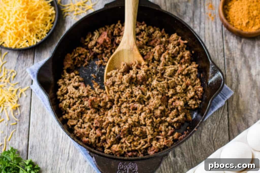 Keto Crustless Taco Casserole 9 Ground beef with taco seasoning in a skillet