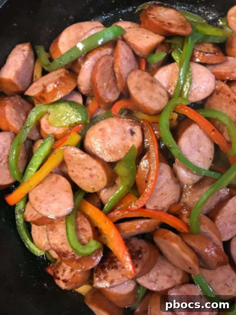 Adding Cooked Kielbasa Sausage Back to the Skillet with Sautéed Peppers for Keto Skillet